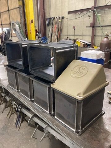 A bunch of metal boxes are stacked on top of each other on a table.