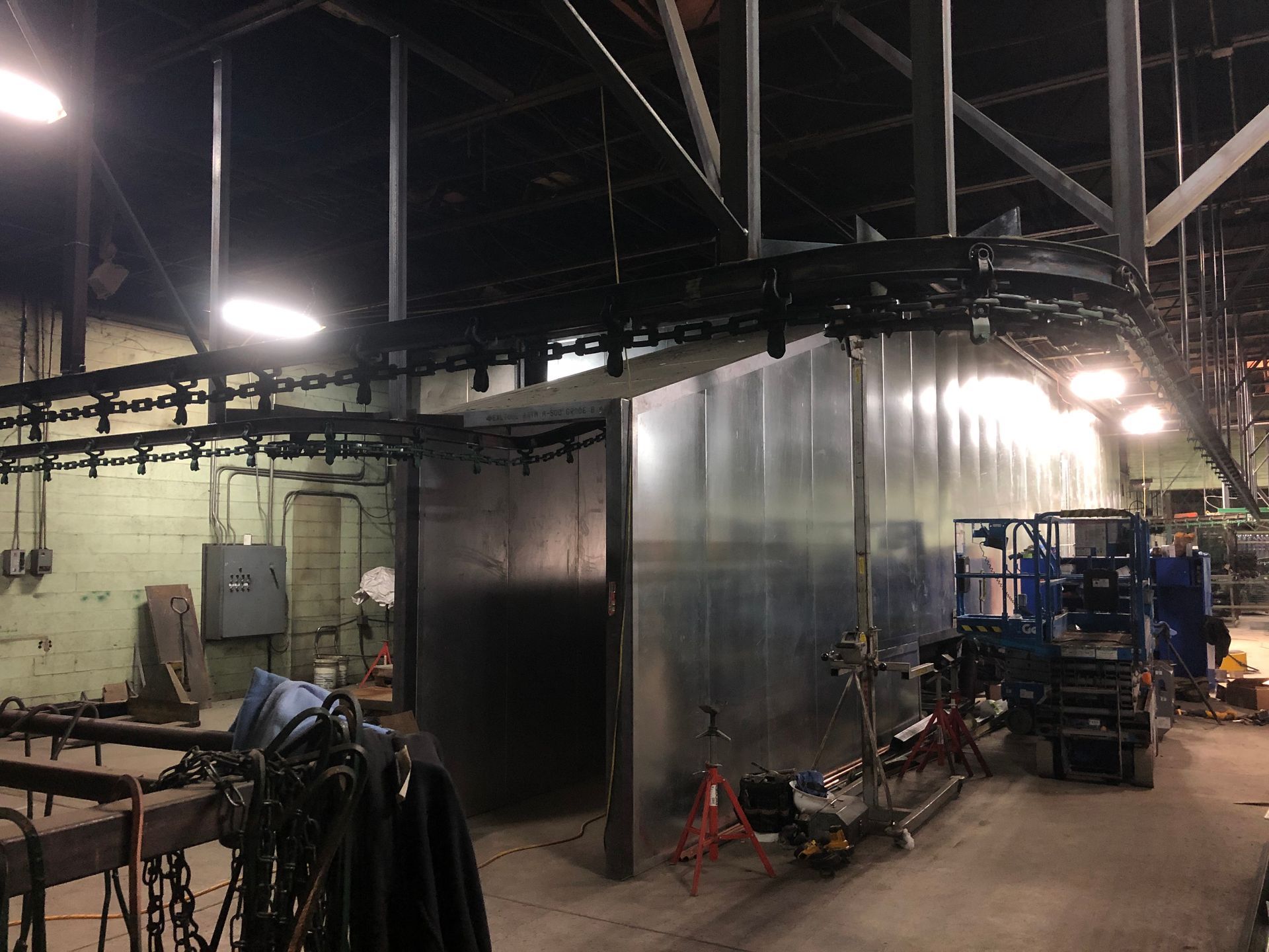 A man is standing in a factory with a conveyor belt.