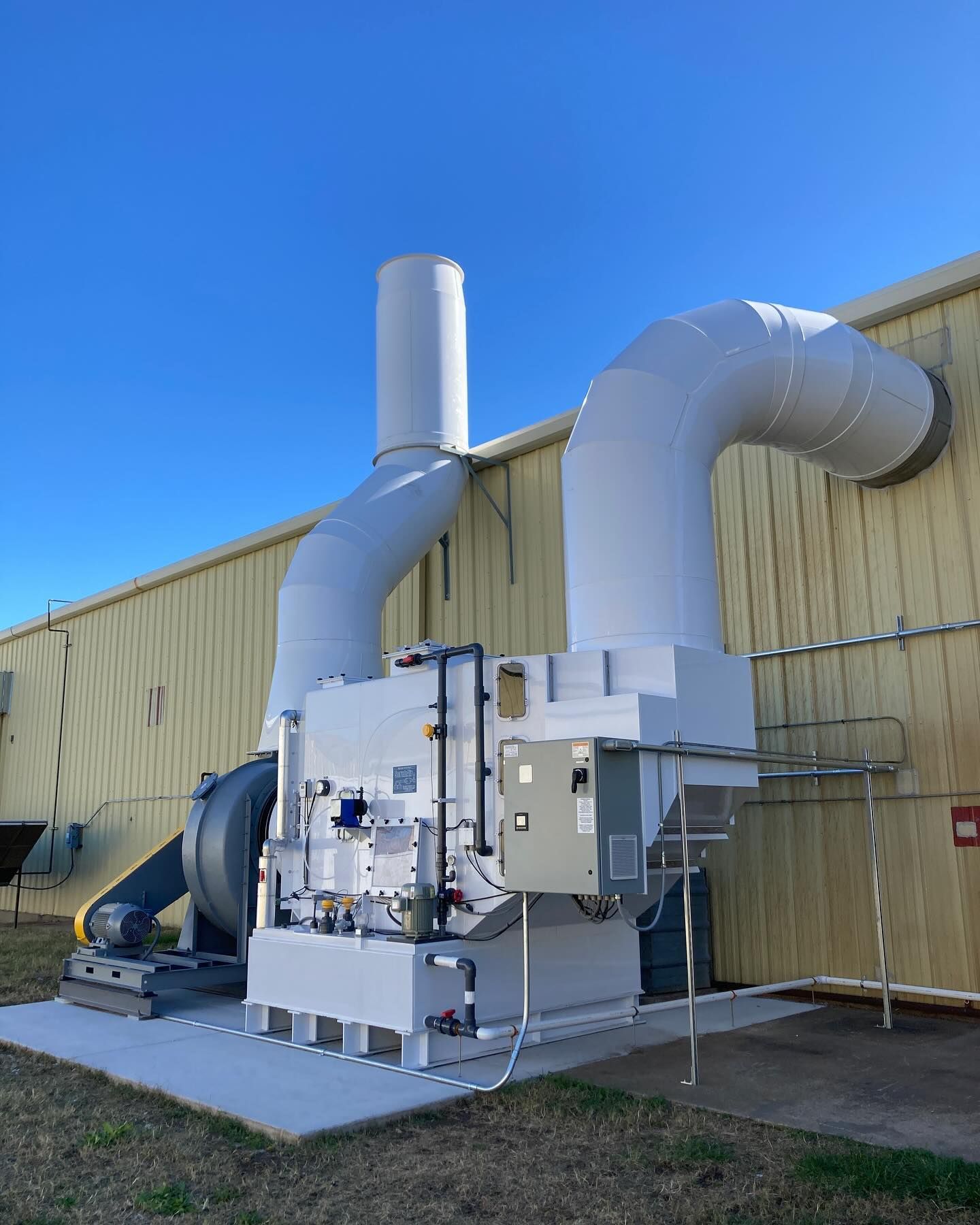A large white machine is sitting in front of a building.