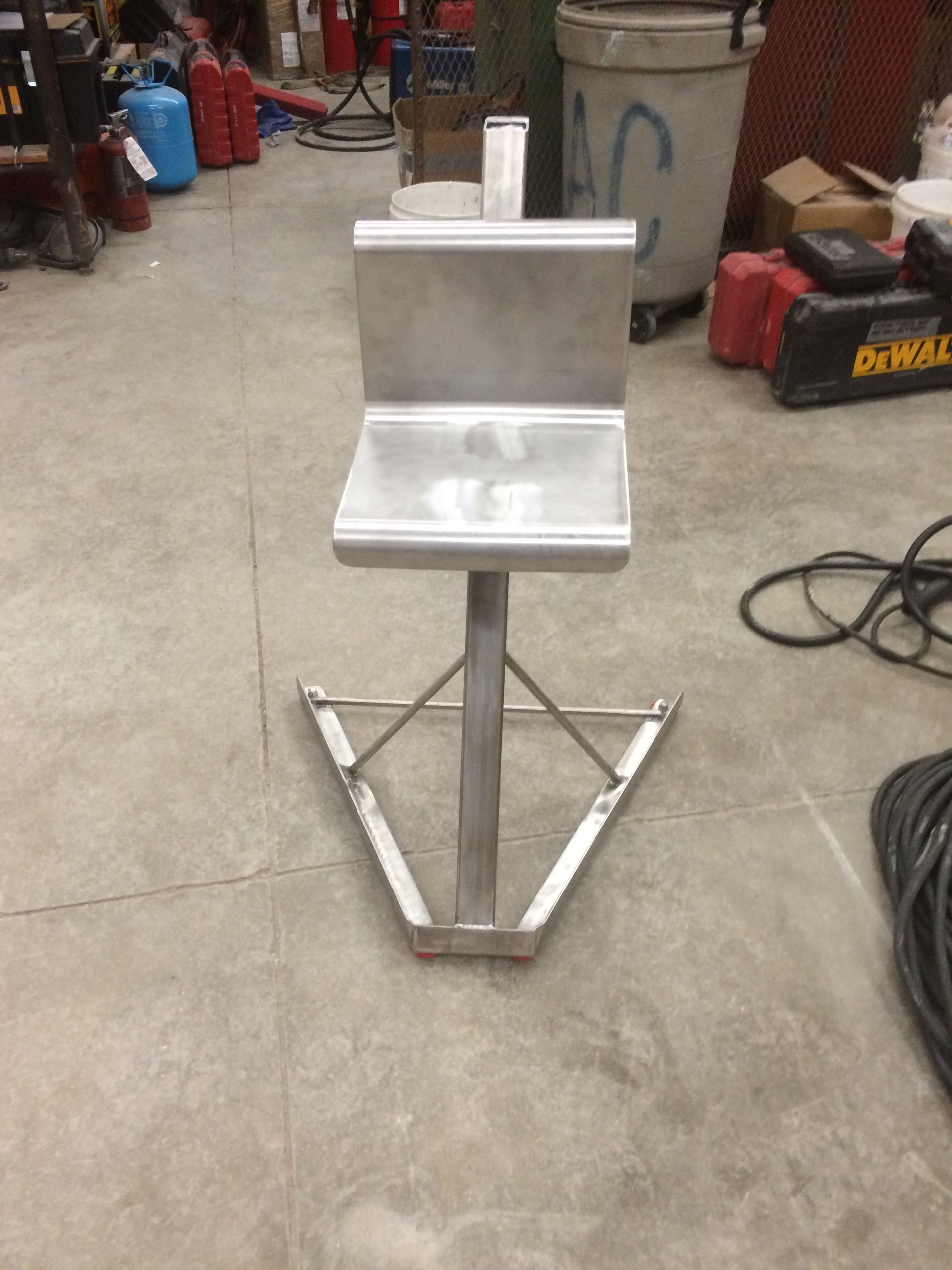 A stainless steel chair is sitting on a concrete floor