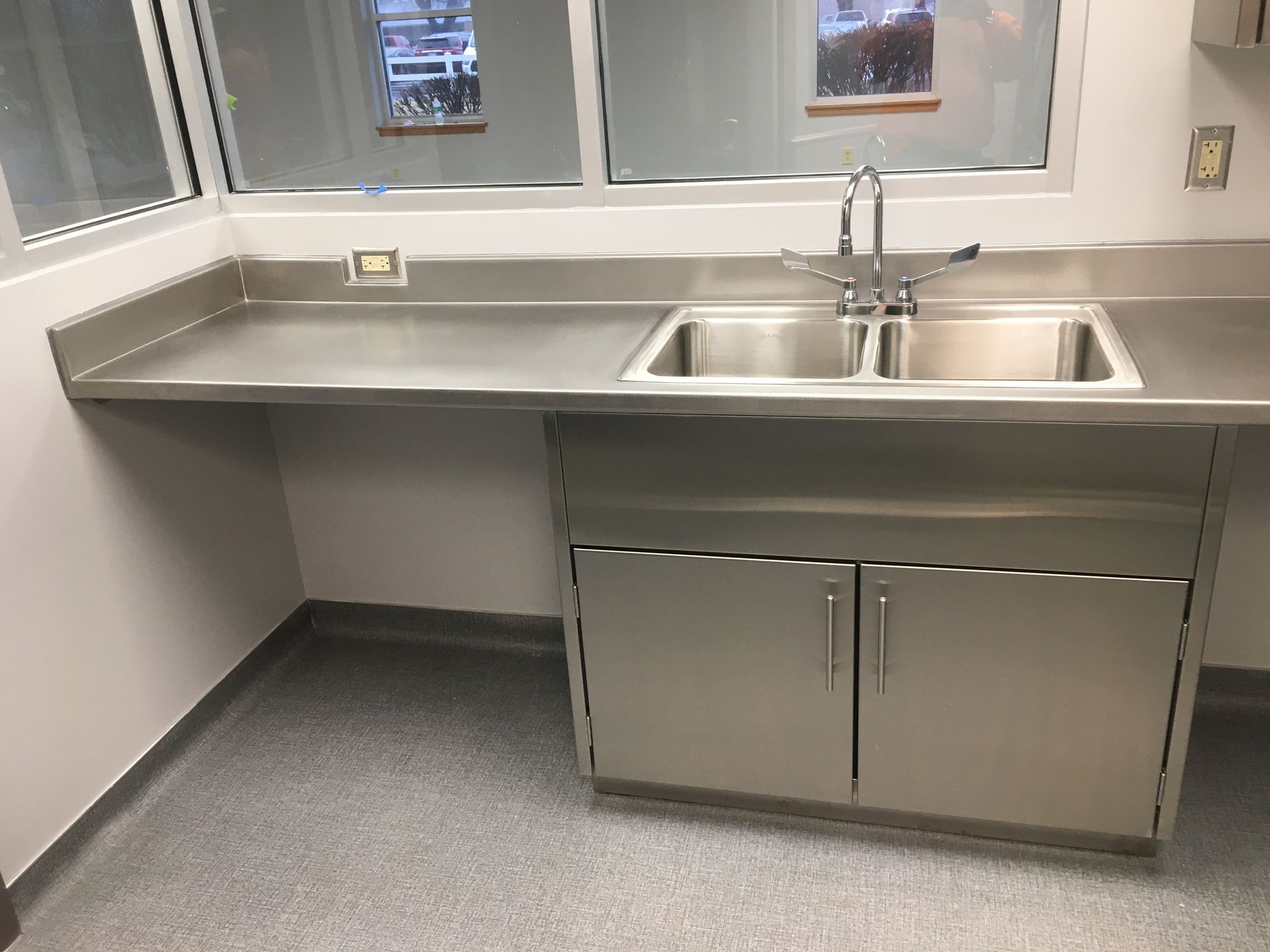 A kitchen with a stainless steel sink and cabinets