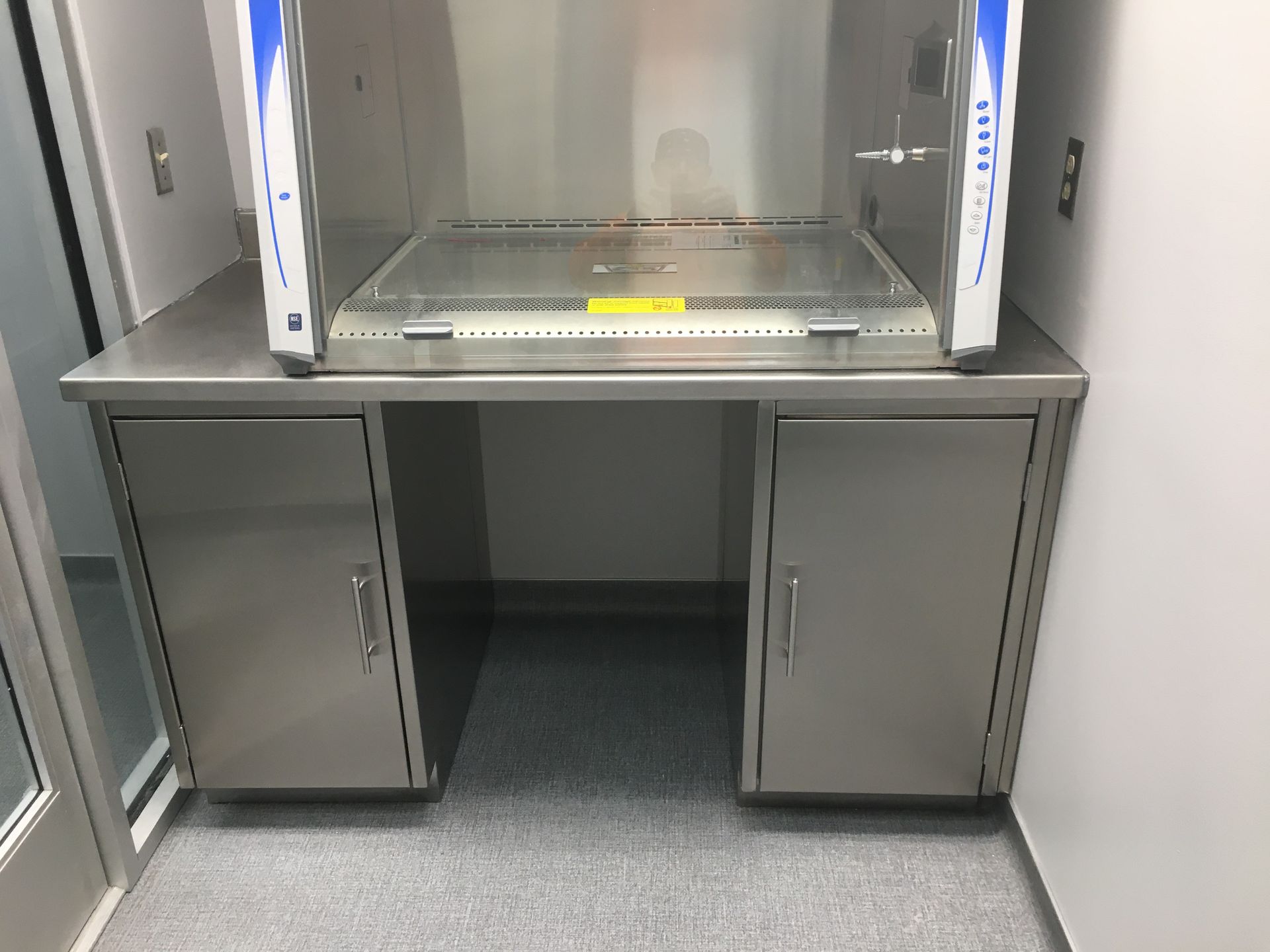 A stainless steel desk with a hood on top of it in a room.