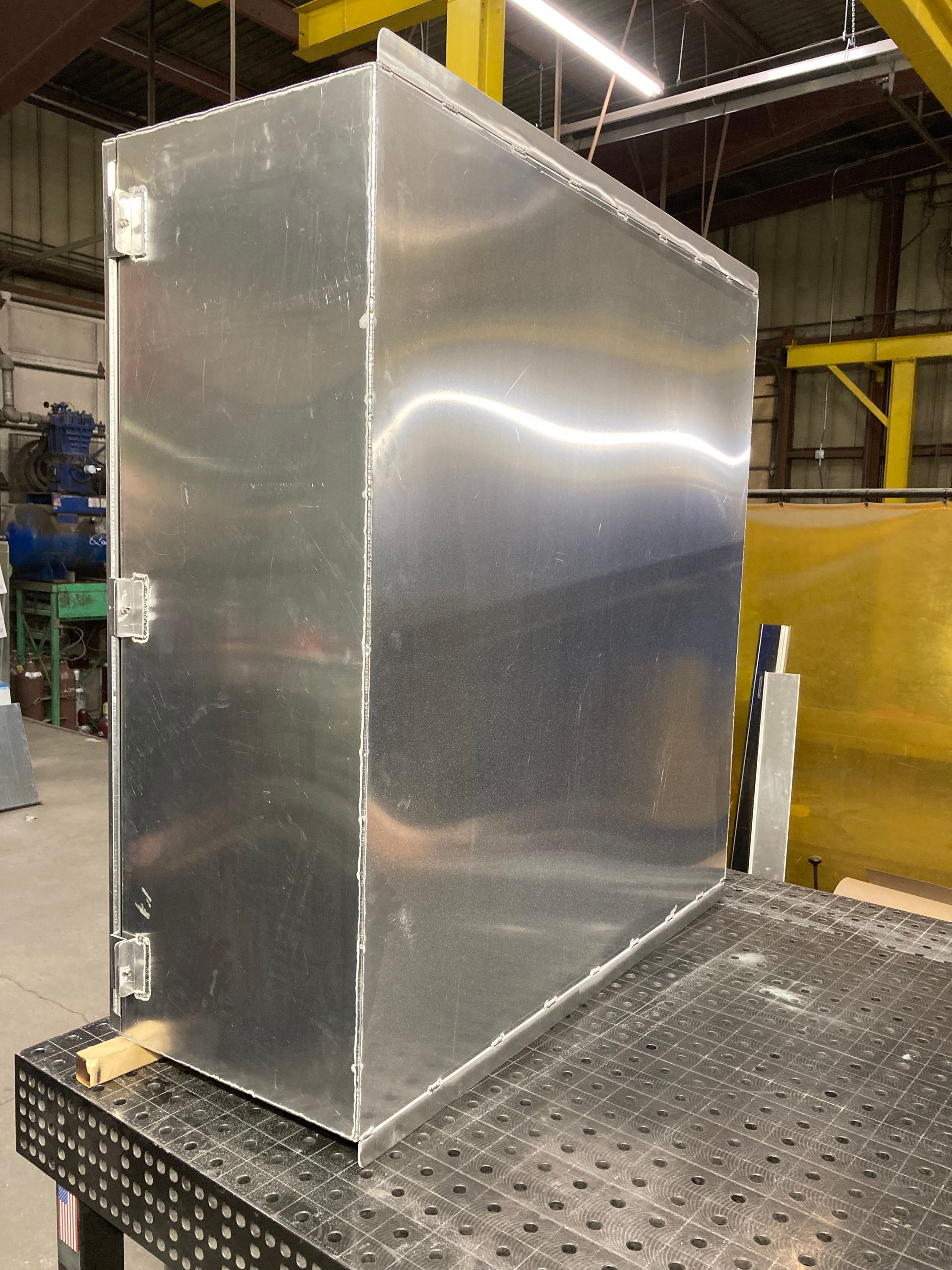 A large aluminum box is sitting on top of a metal table.
