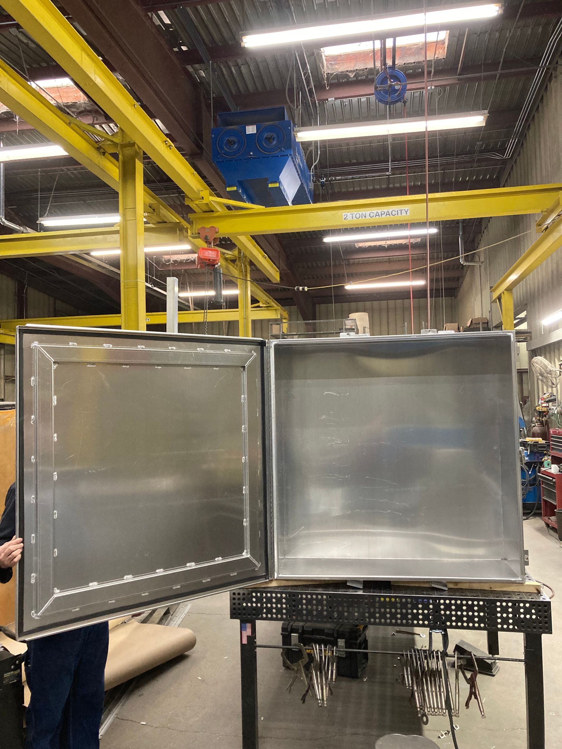 A stainless steel box is sitting on a table in a factory