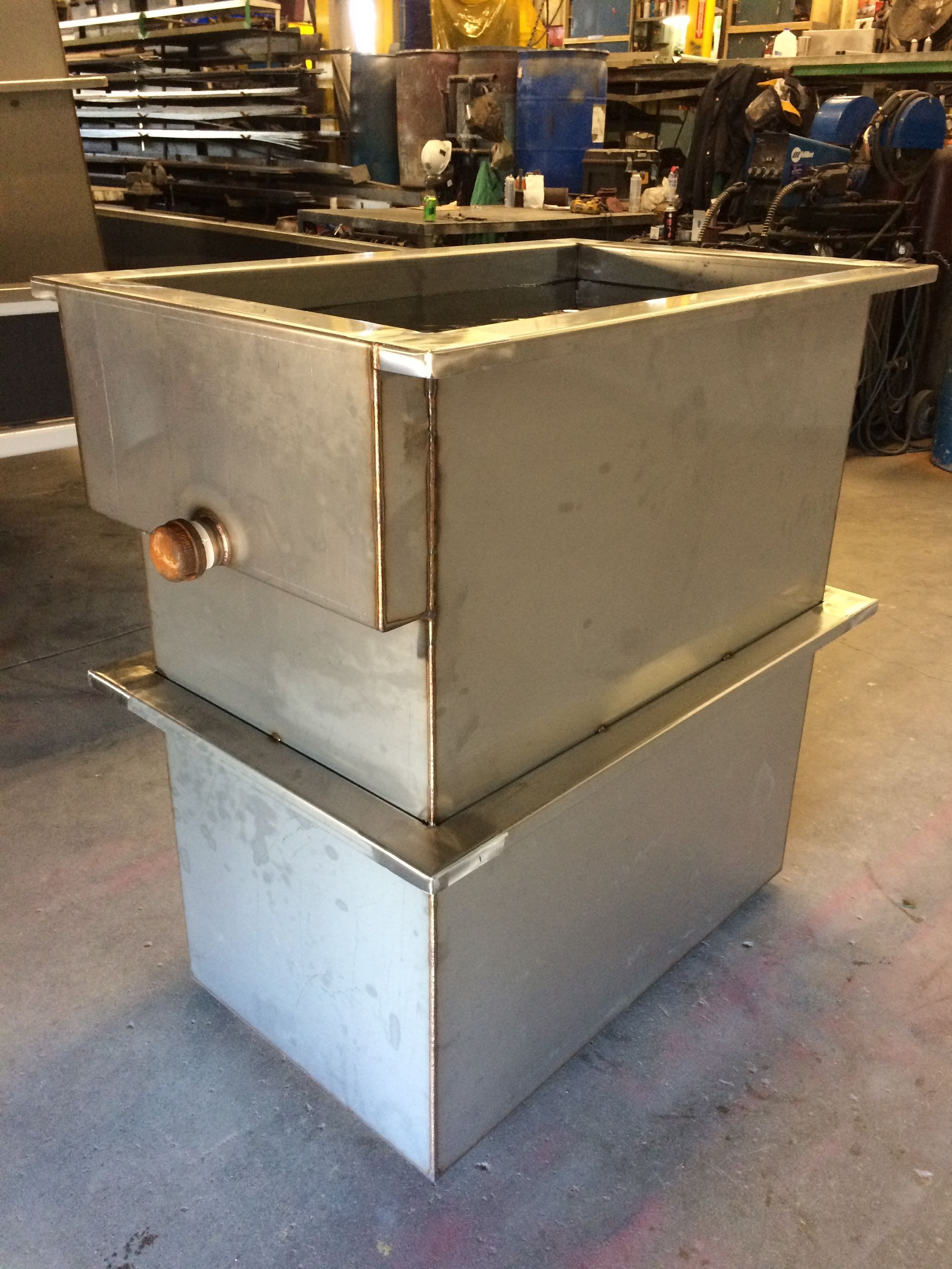 A stainless steel tank is sitting on top of another stainless steel tank.