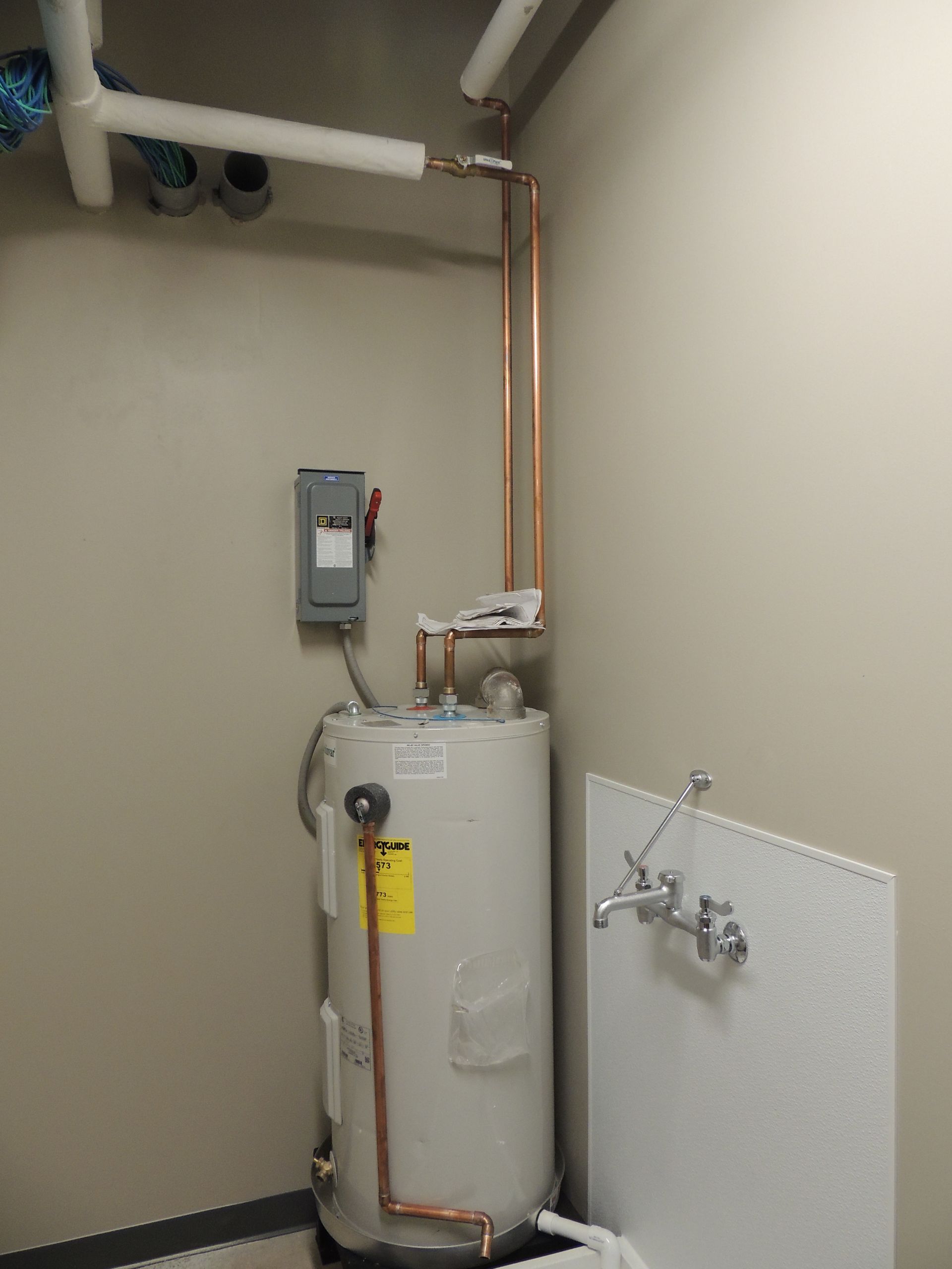 There is a water heater in the corner of the room.