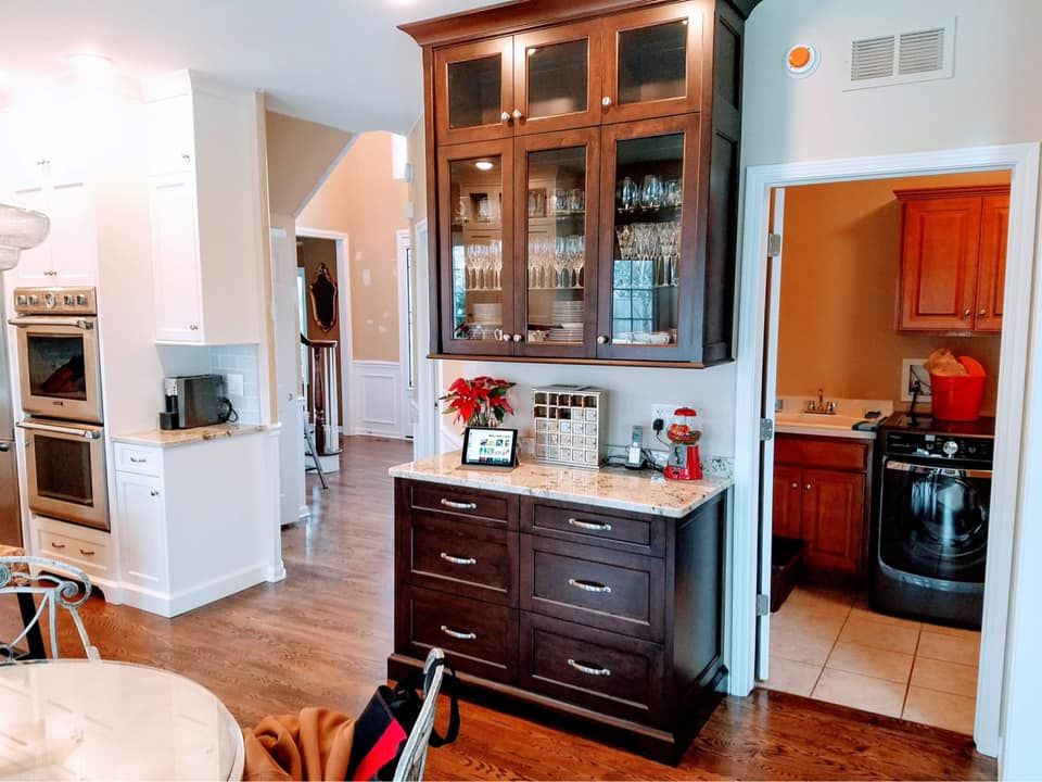Warm kitchen with dark wood cabinets, island, and a doorway to a laundry room.