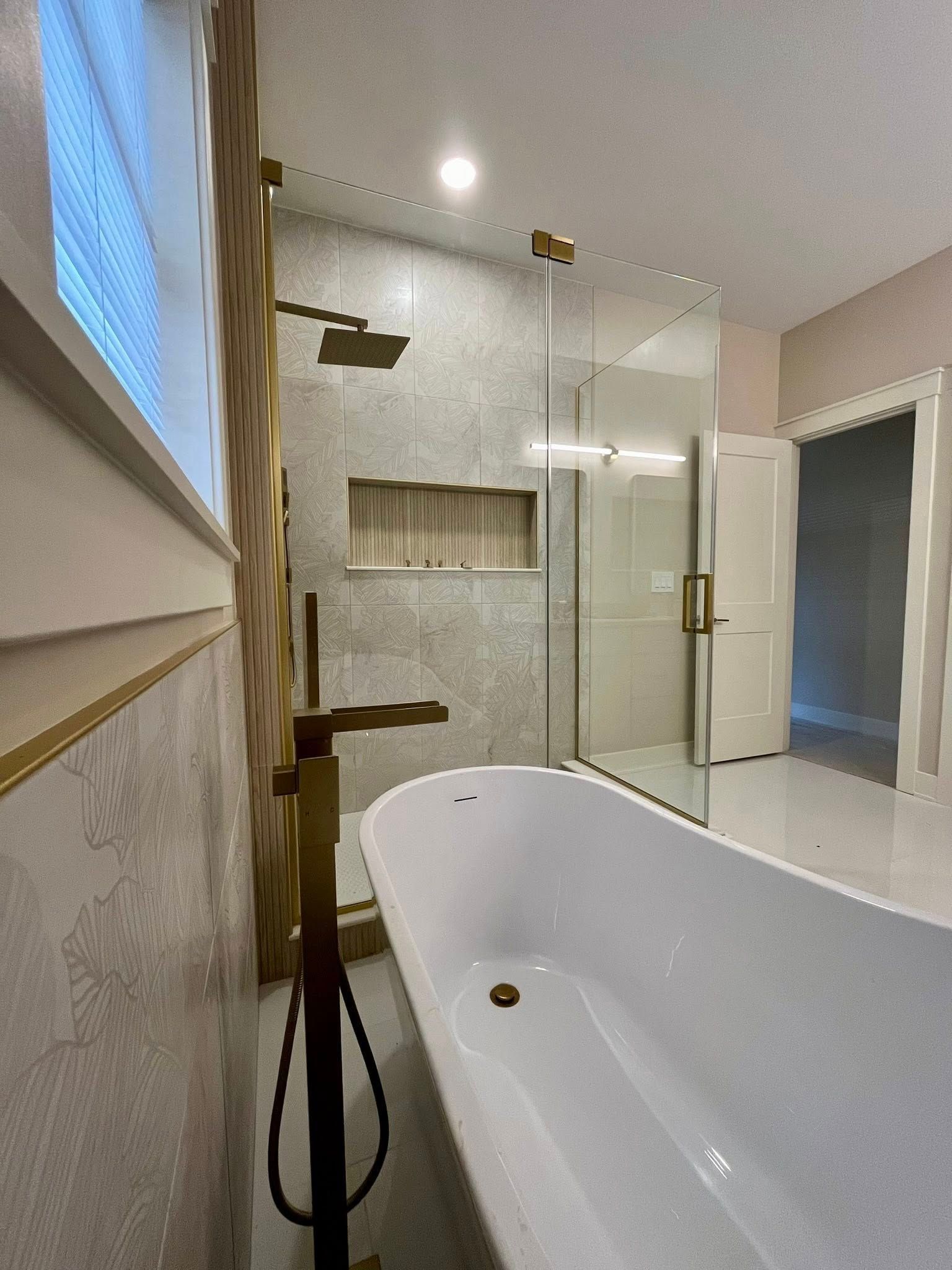 Modern bathroom with white tub, glass shower, and wood vanity details