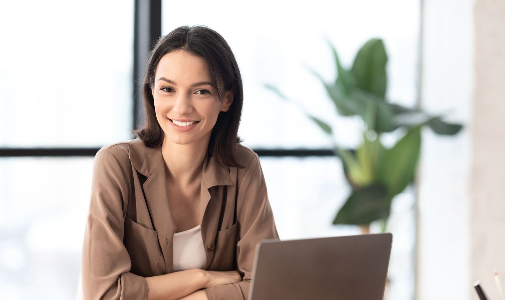 A woman is sitting at a desk with a laptop computer.