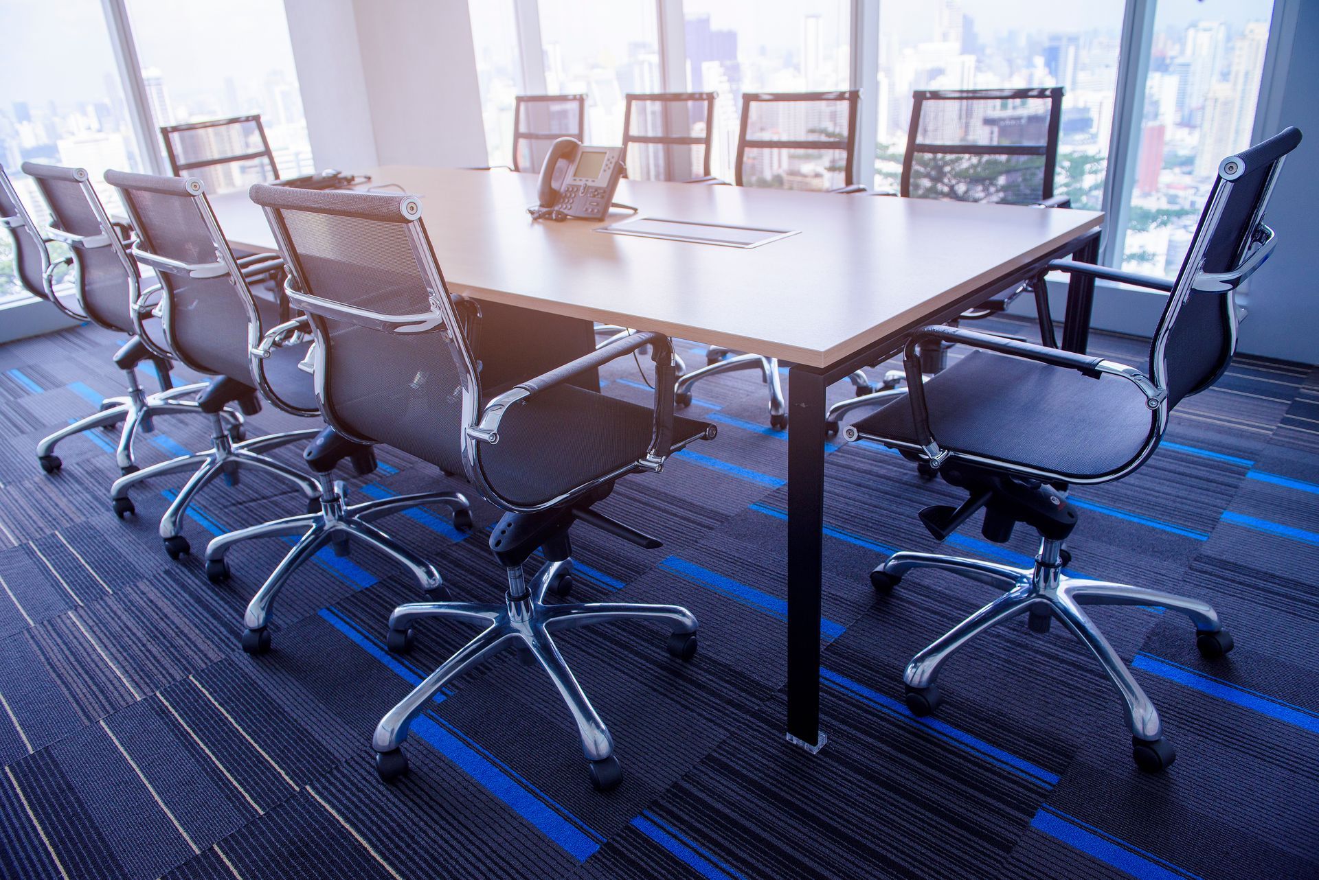 A conference room with a long table and chairs.