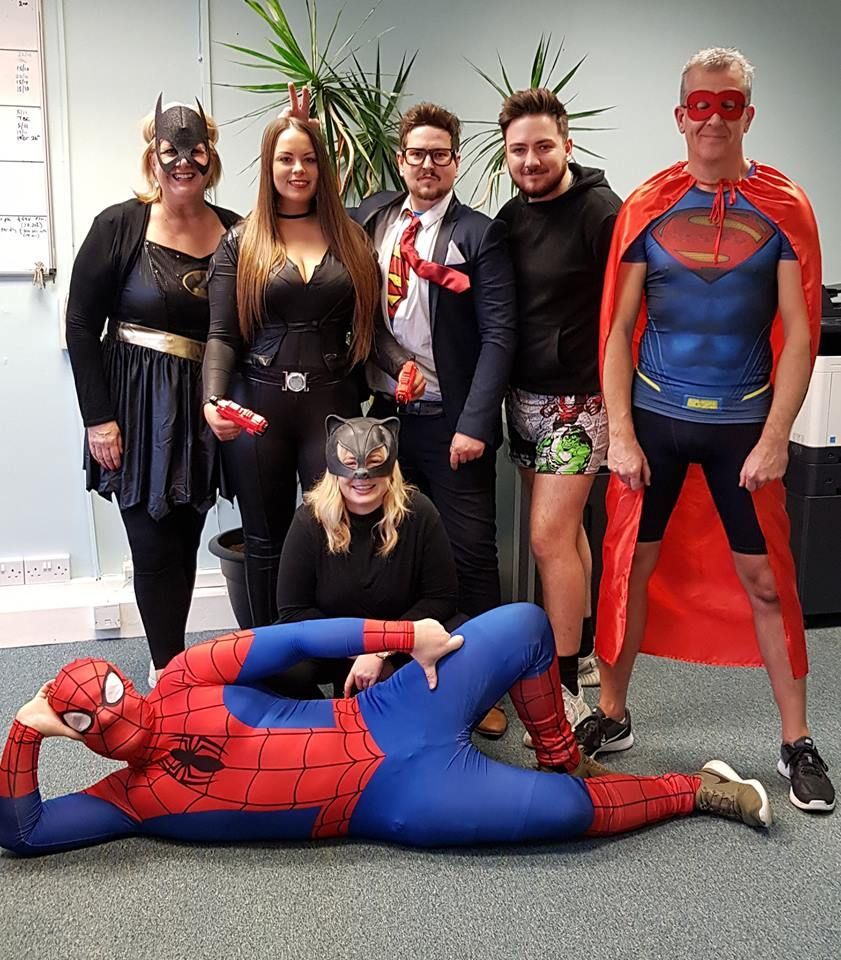 A group of people dressed in superhero costumes are posing for a picture.