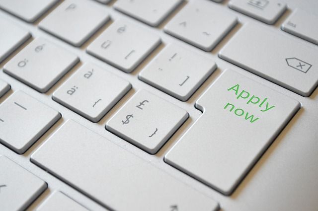 A white keyboard with a green apply now key