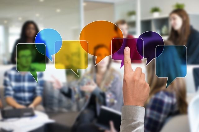 A person is pointing at a speech bubble in front of a group of people.