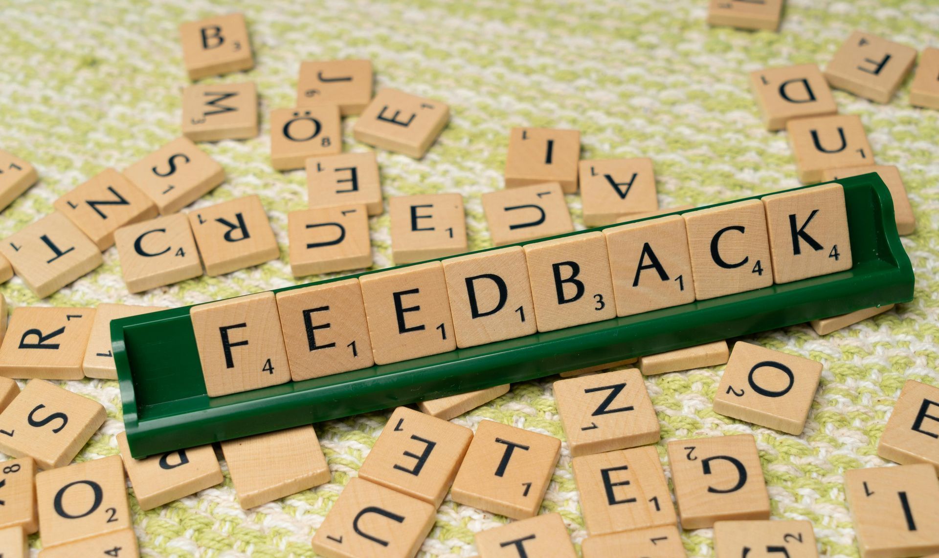 A scrabble board with the word feedback written on it