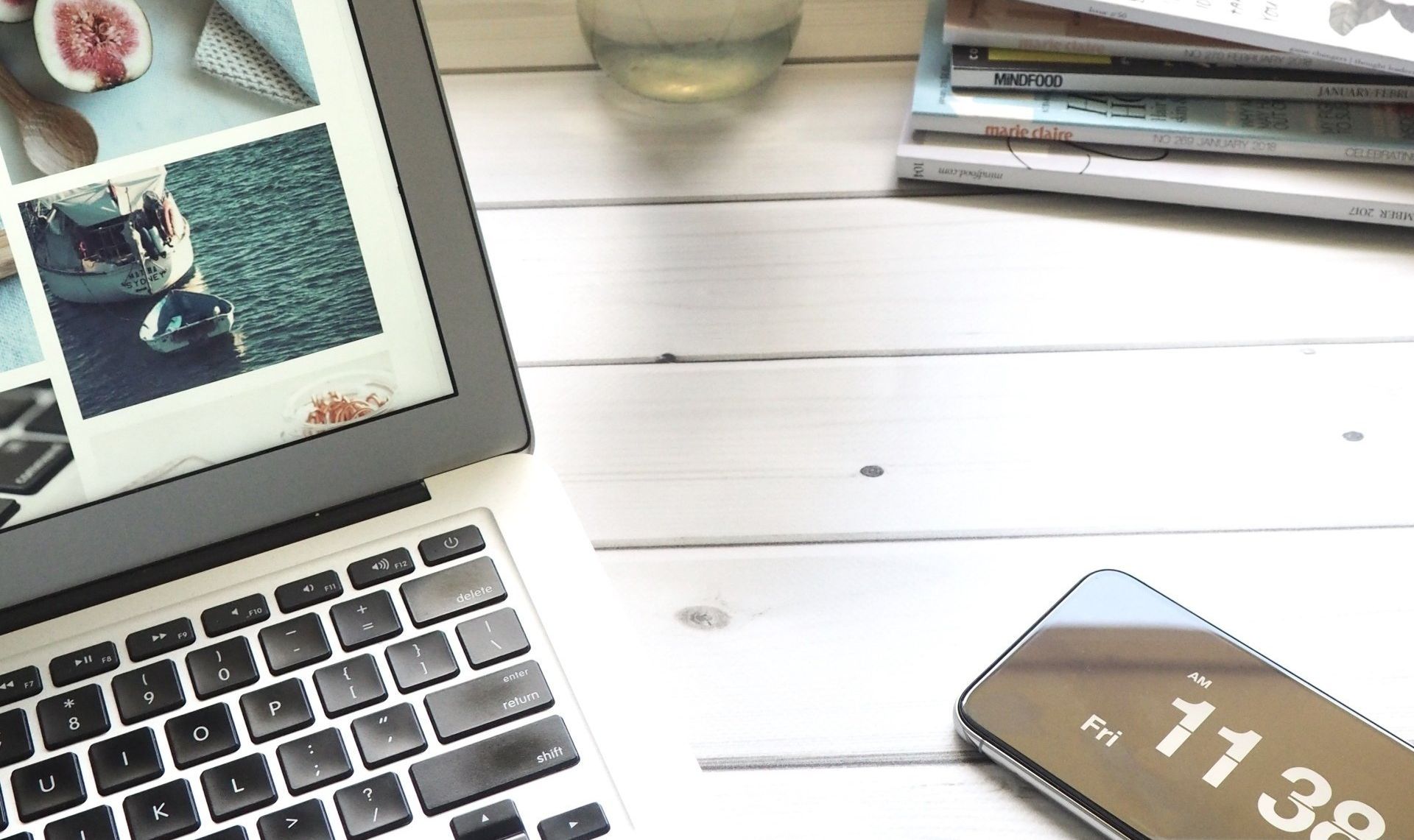 A laptop and a cell phone are on a wooden table.
