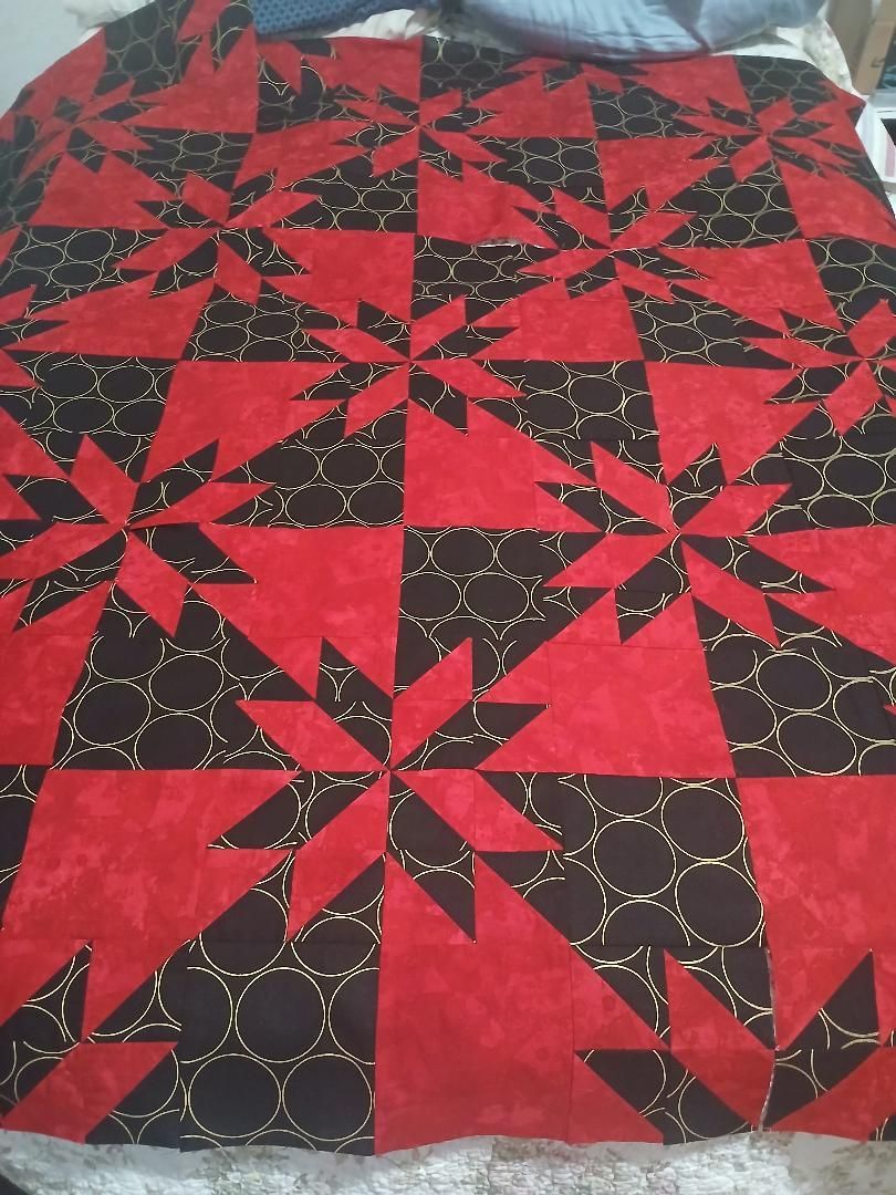 Red and black quilt with star and pinwheel patchwork pattern