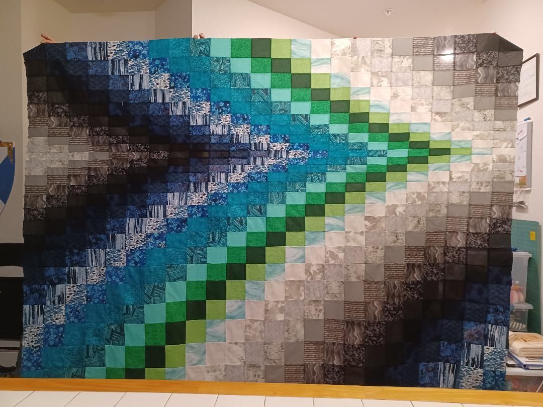 Abstract blue, green, and white geometric mural with a bright triangular center on a wall