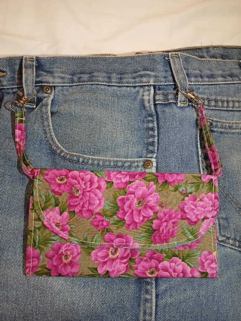 Blue jeans with a pink floral fabric patch pocket on the back
