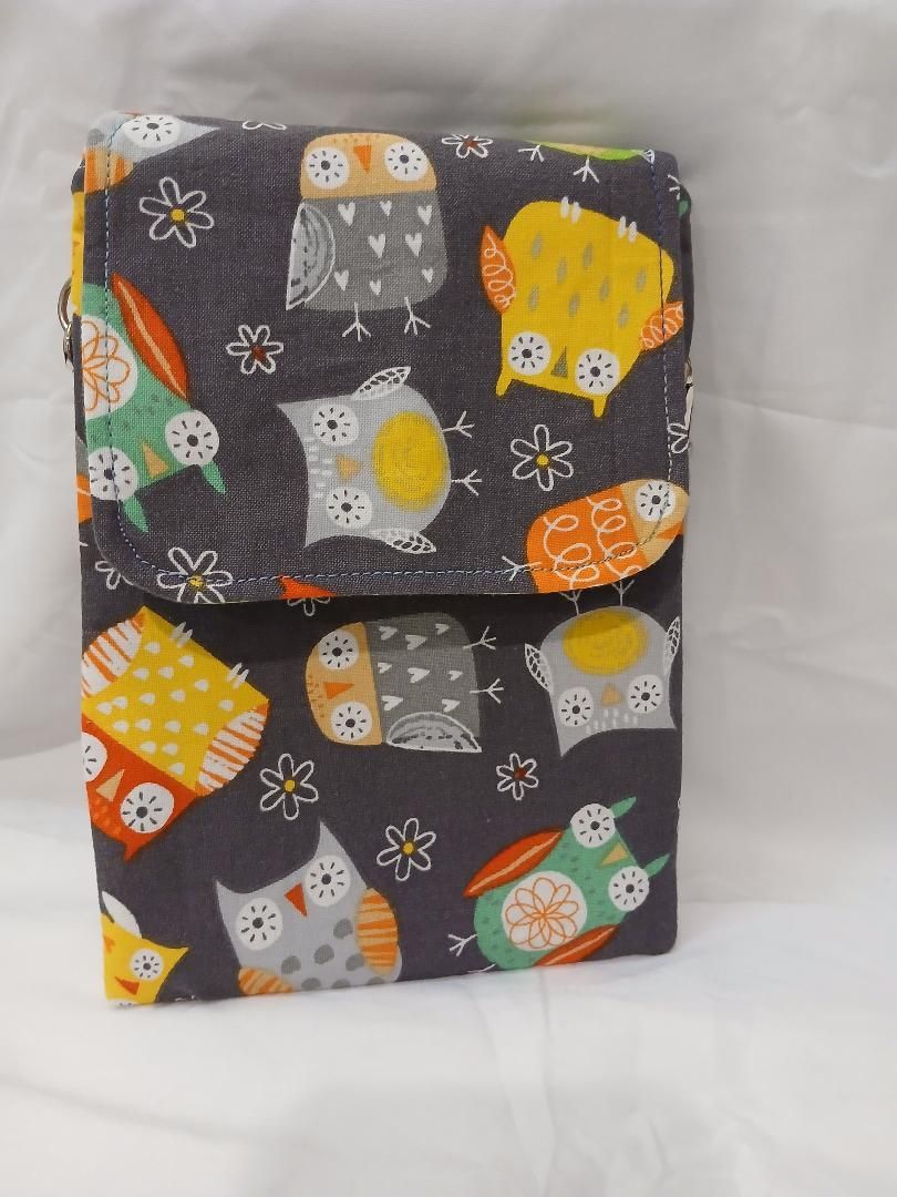 Gray owl-print fabric bag with orange and yellow accents, folded and standing upright on a light background