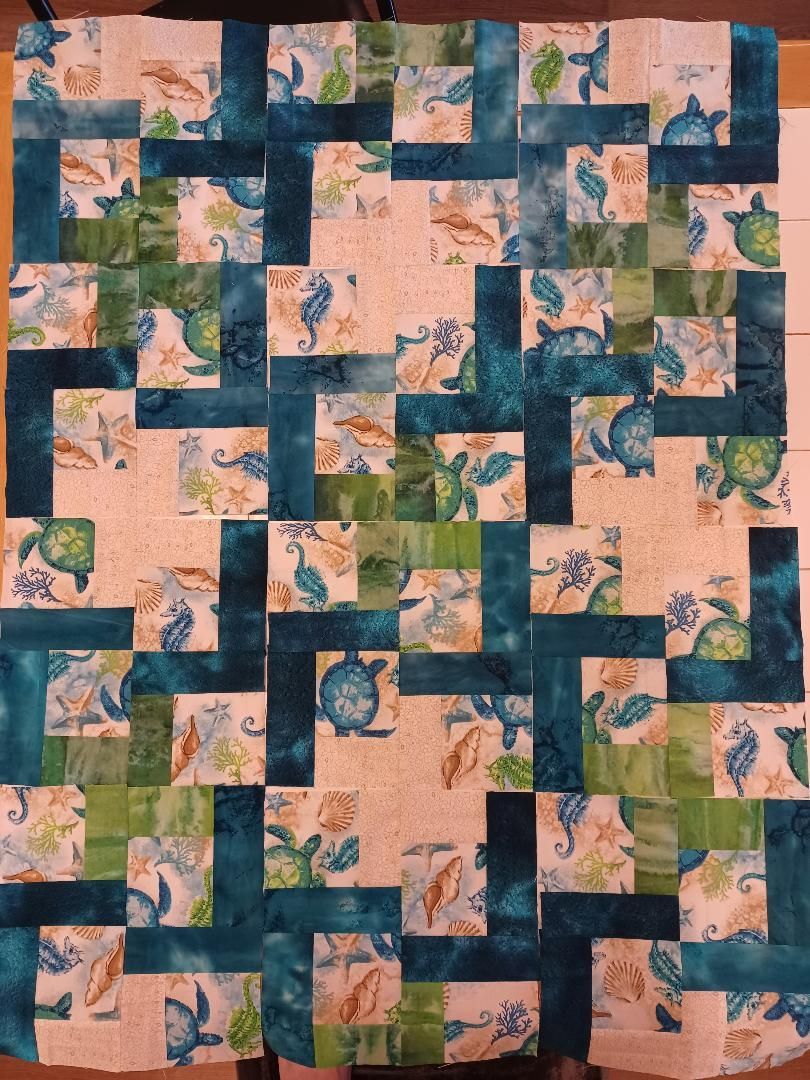 Abstract quilt pattern with interlocking navy, peach, and pink blocks in a woven geometric design