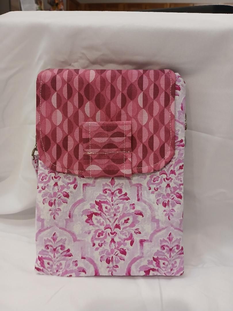 Pink patterned fabric pouch or wallet on a white cloth background