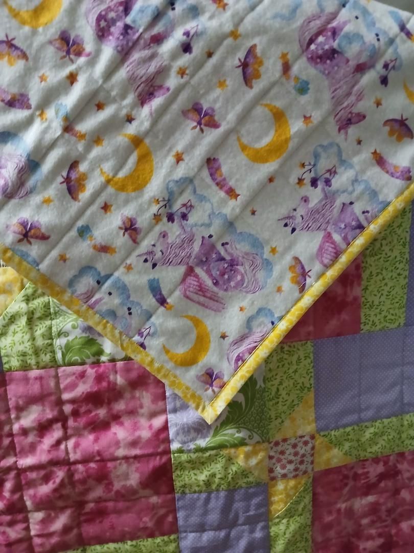 Close-up of a colorful quilt with moon and floral prints in pastel patches