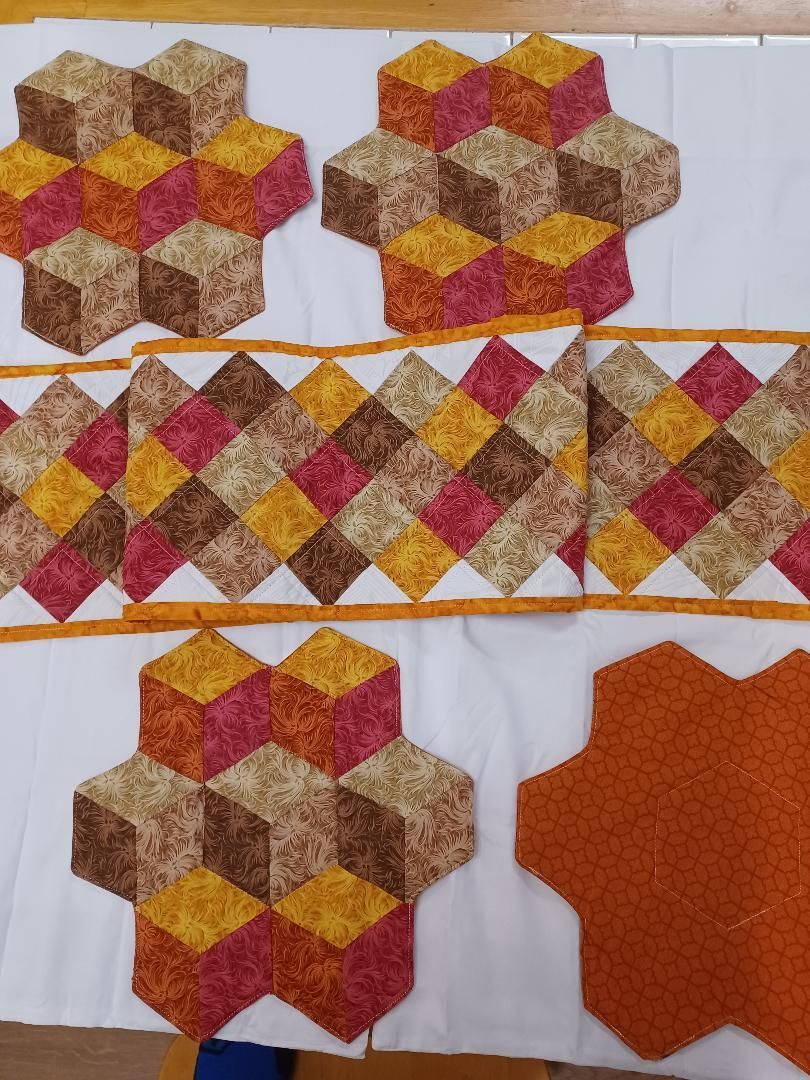 Geometric fabric patchwork with gold, red, and brown diamond patterns on white background