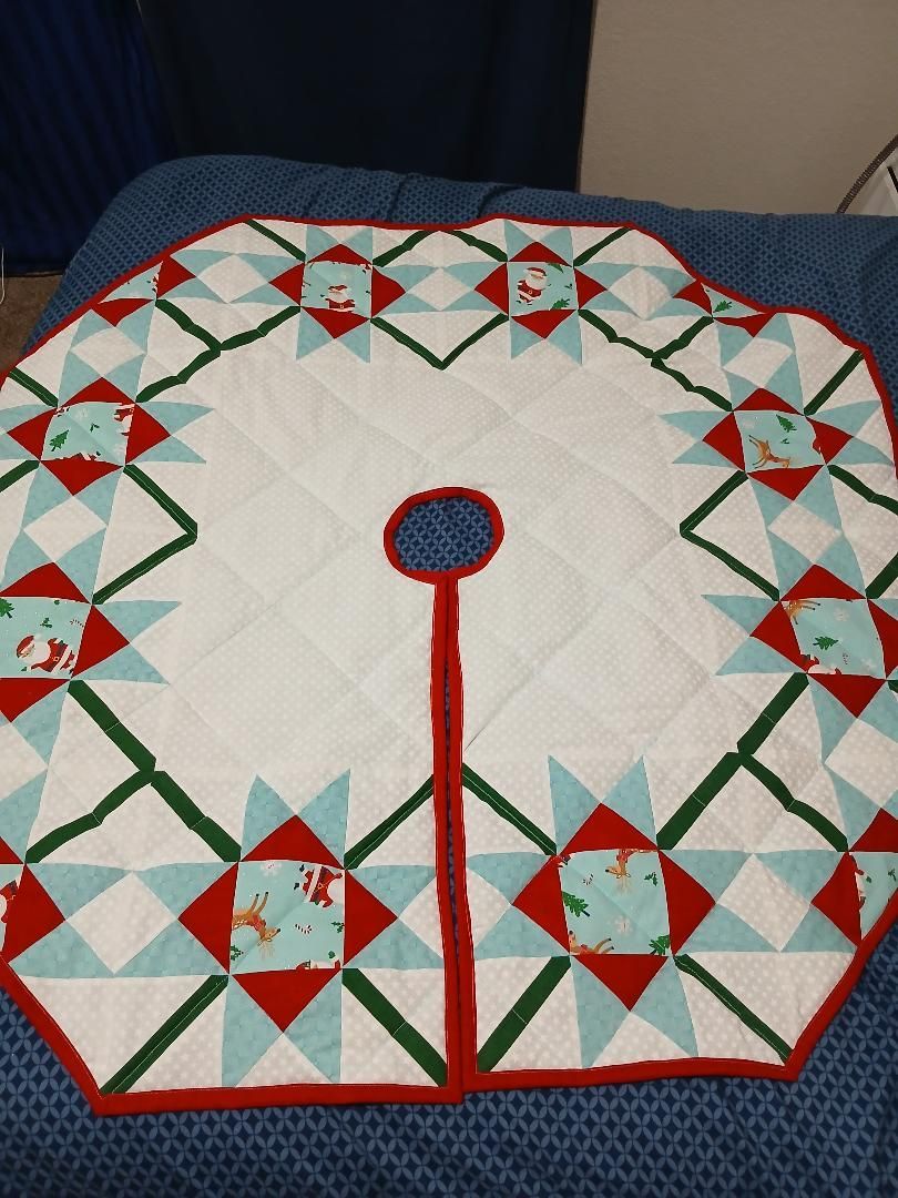 Quilted red, green, and white circular wall hanging on a blue couch