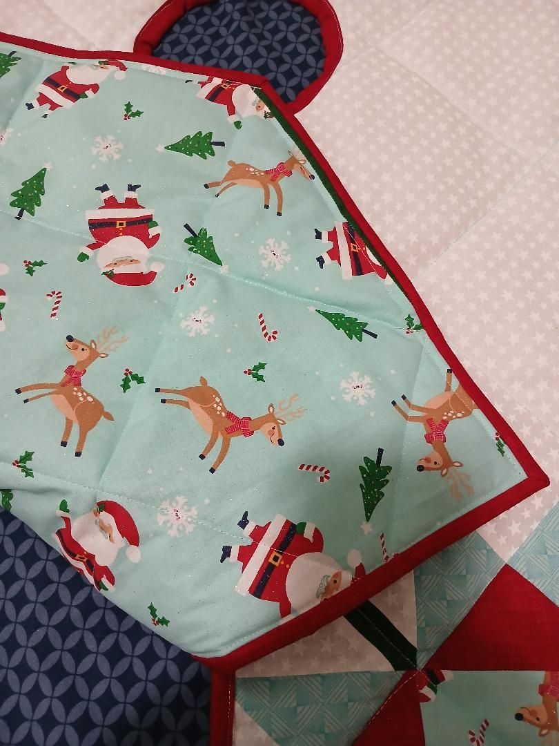 Christmas-themed mint green quilted bag with Santa and reindeer prints, red trim, and a black strap