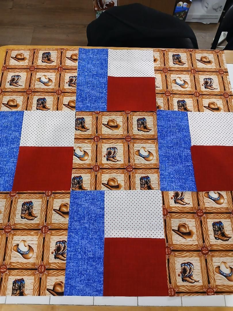 Colorful patchwork quilt with blue, red, white, and tan patterned squares.