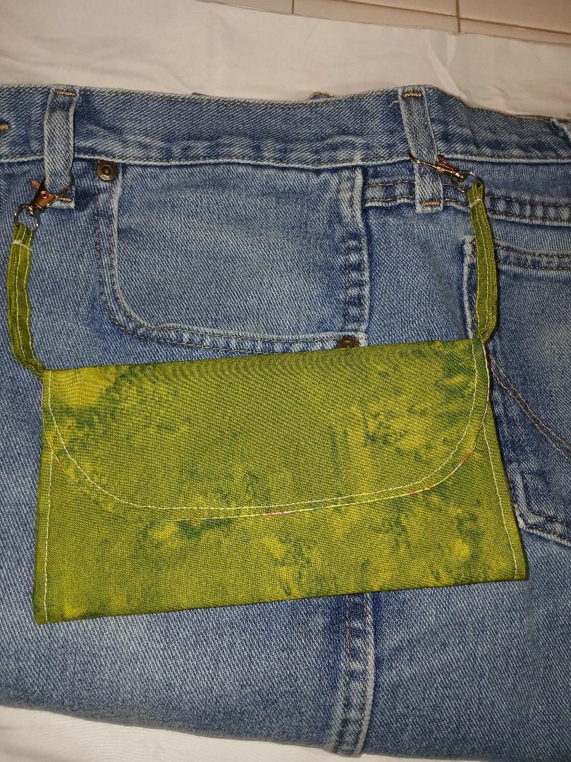 Green patch sewn onto blue denim jeans pocket area
