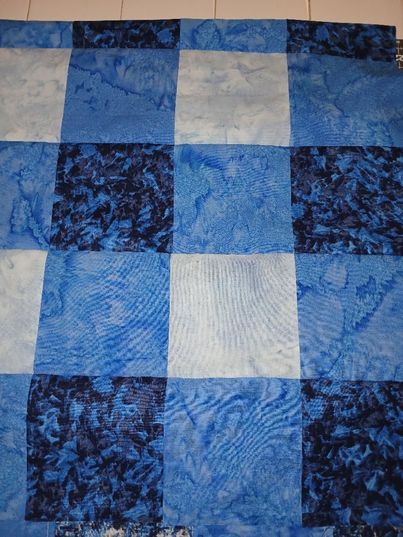Blue and white patchwork quilt with textured square patterns