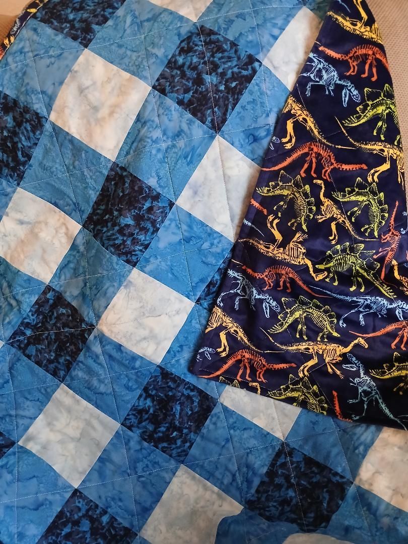 Blue-and-white quilt with a dark patterned fabric panel on the right side