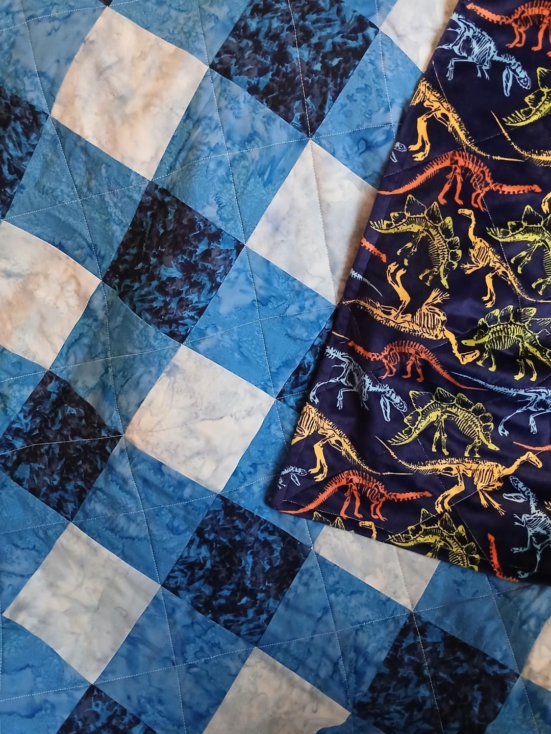 Blue and white quilt with a patterned dark fabric panel on the right