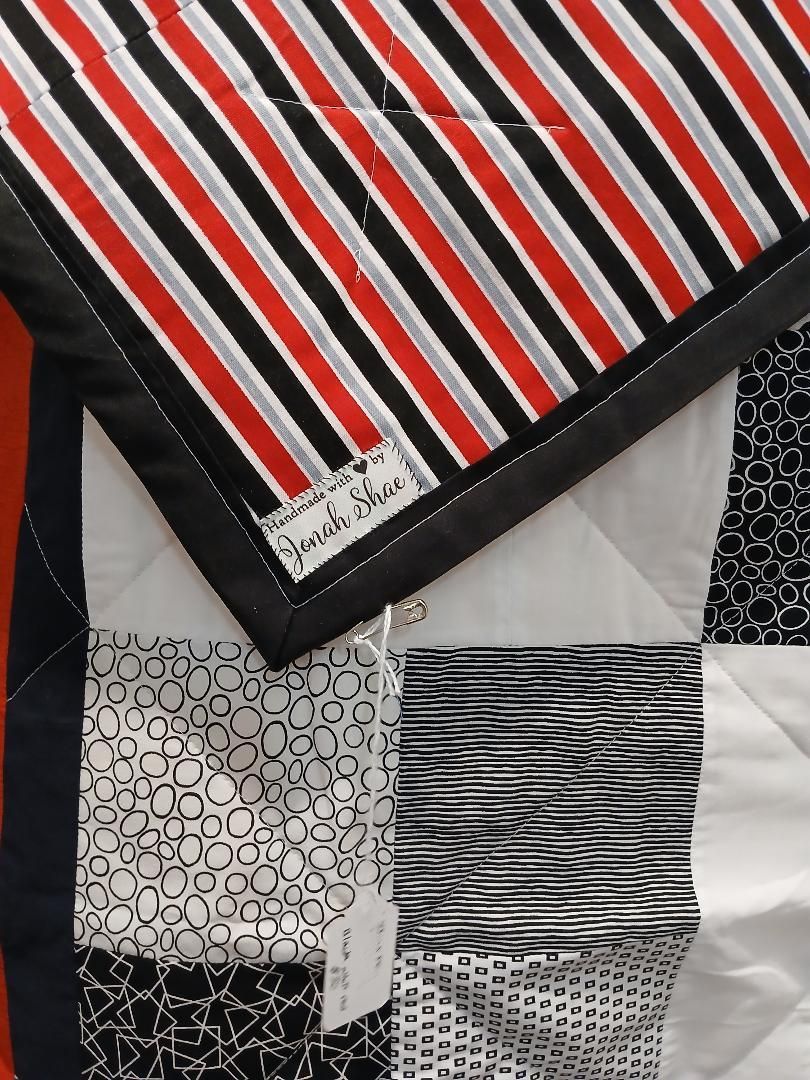 Patchwork fabric with red, black, and white striped and patterned sections