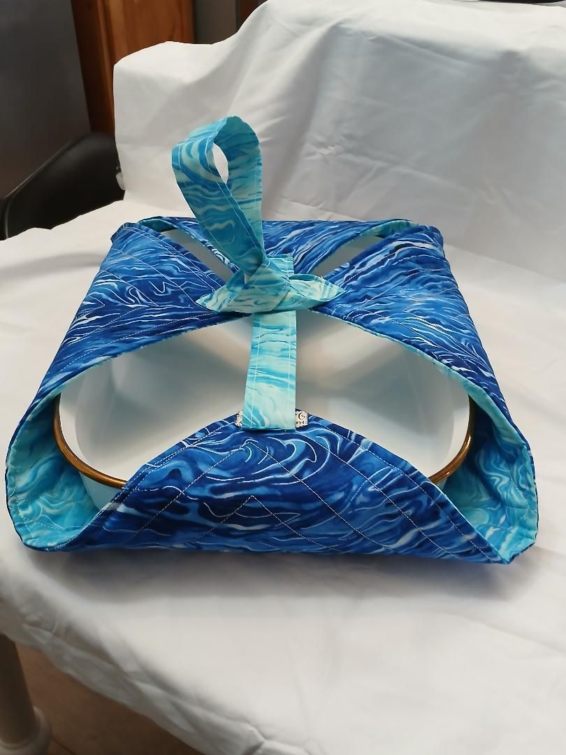 Blue handmade paper craft with a white circular opening, sitting on a chair