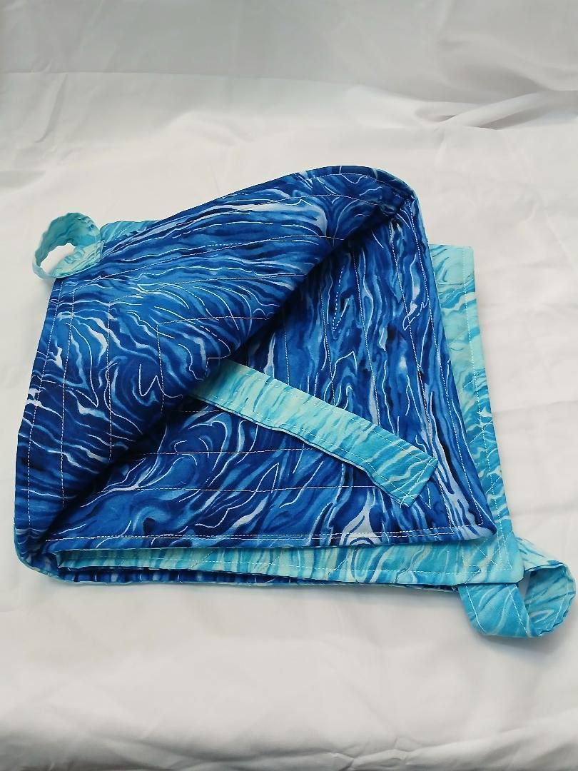 Blue patterned fabric pouch with light blue trim and tie strings on a white surface