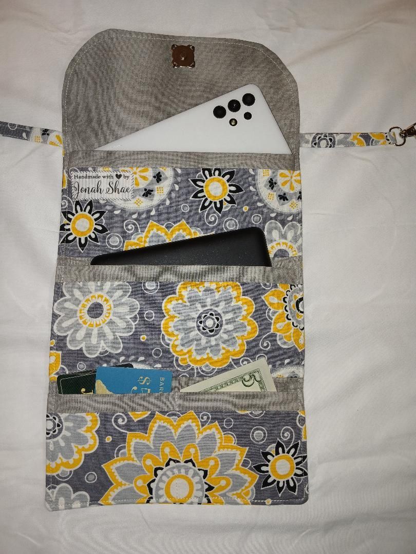 Patterned fabric wall organizer with multiple pockets hanging on a white background