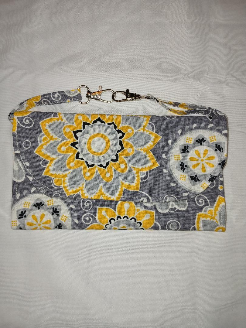 Gray and yellow floral zippered pouch on a light fabric background