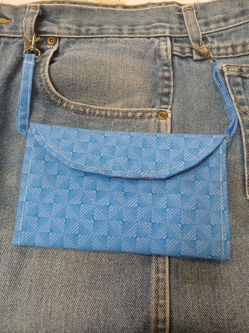 Blue patterned fabric pouch clipped to the back pocket of blue denim jeans