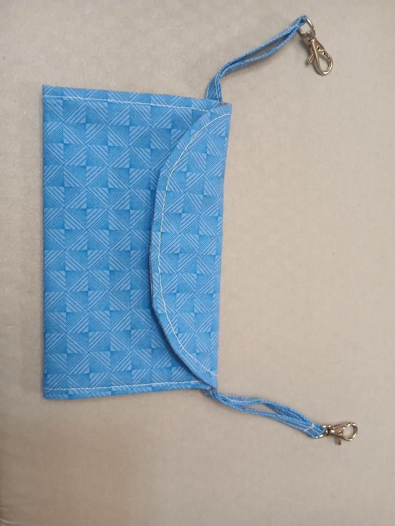 Blue patterned zip pouch with a curved flap and two braided cords with metal clips.