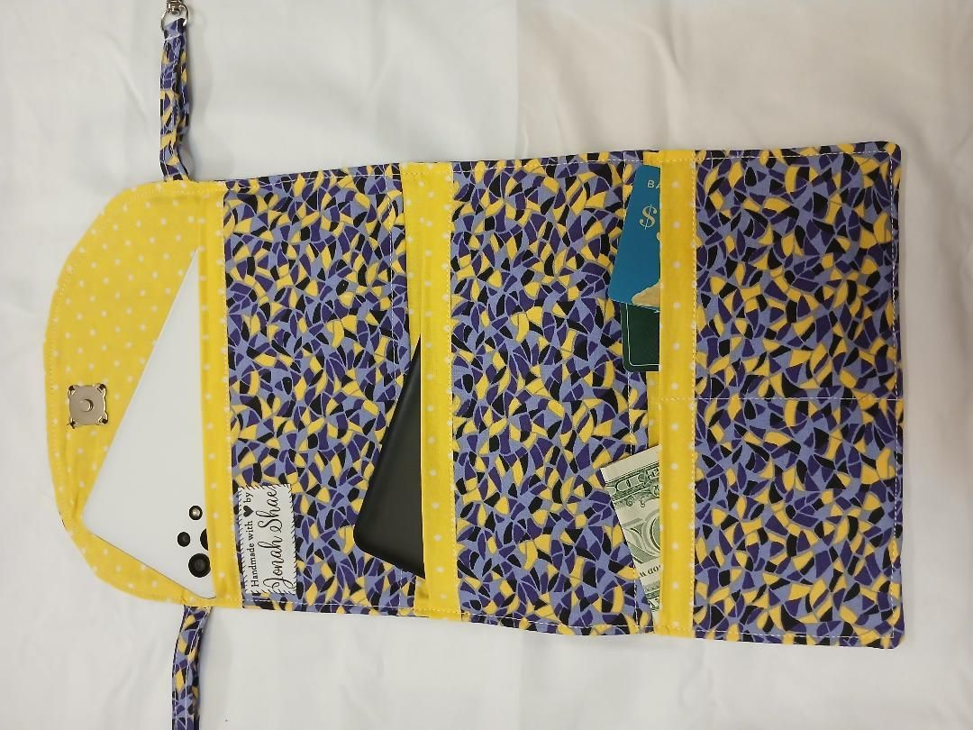 Patterned yellow-and-blue hanging organizer with multiple pockets and zipper compartments