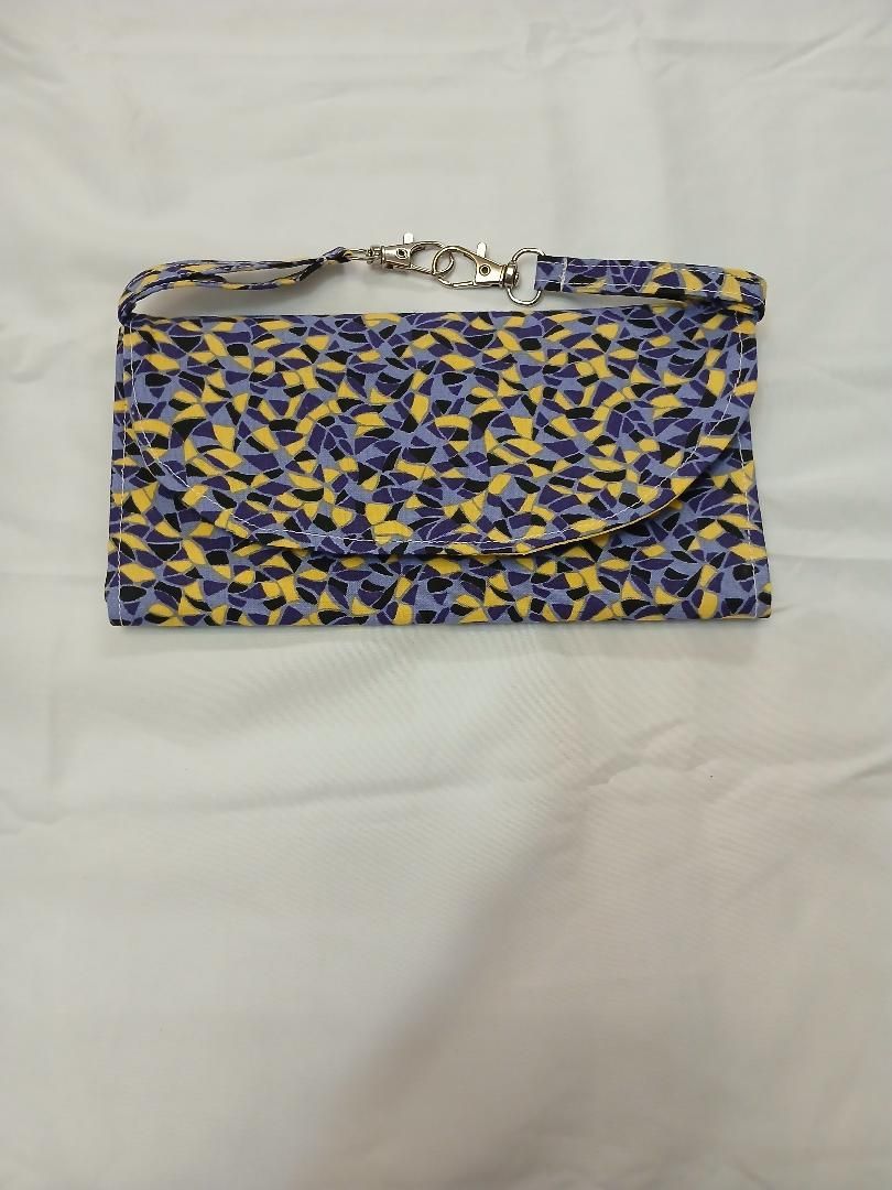 Blue-and-yellow patterned zippered clutch on a white background