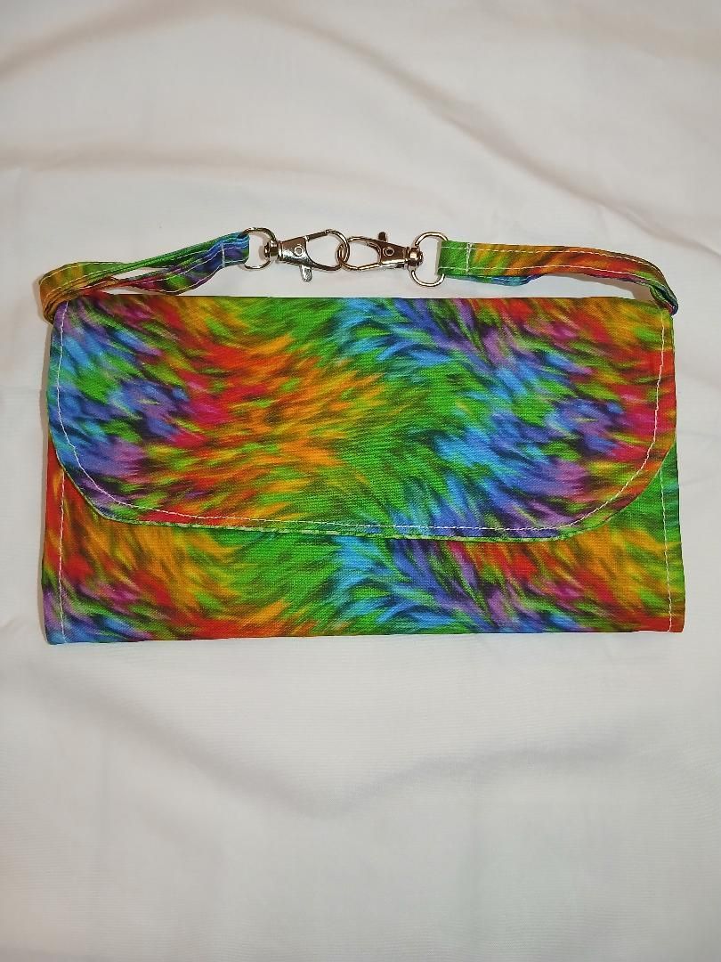 Rainbow tie-dye clutch purse with a metal chain handle on a white background
