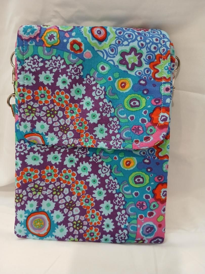 Folded colorful floral fabric with purple, blue, green, and orange floral patterns