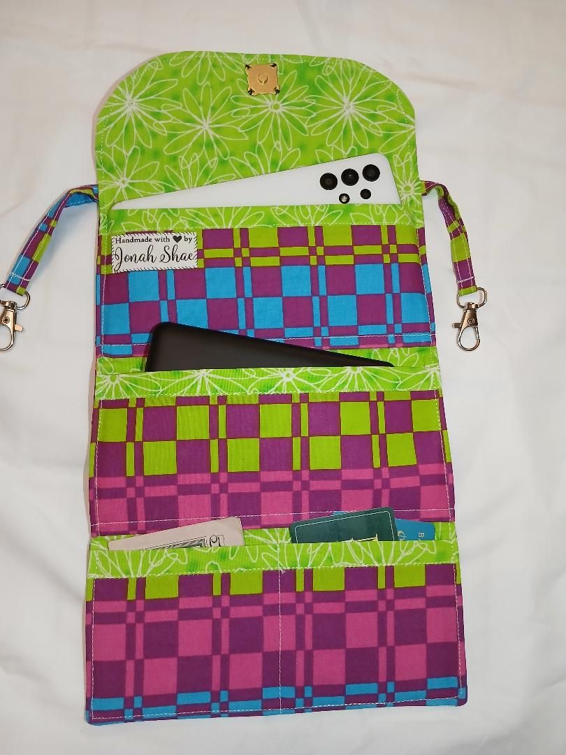 Colorful patchwork hanging organizer with green top and pink, blue, and purple pockets