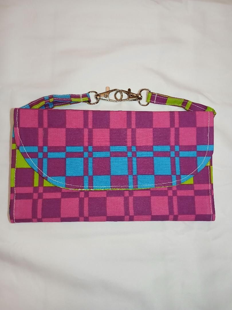 Pink and blue checkered clutch bag with a colorful strap on a white background