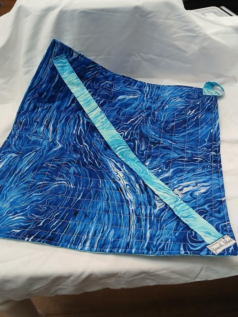 Blue patterned fabric piece with a diagonal light-blue trim on a white surface