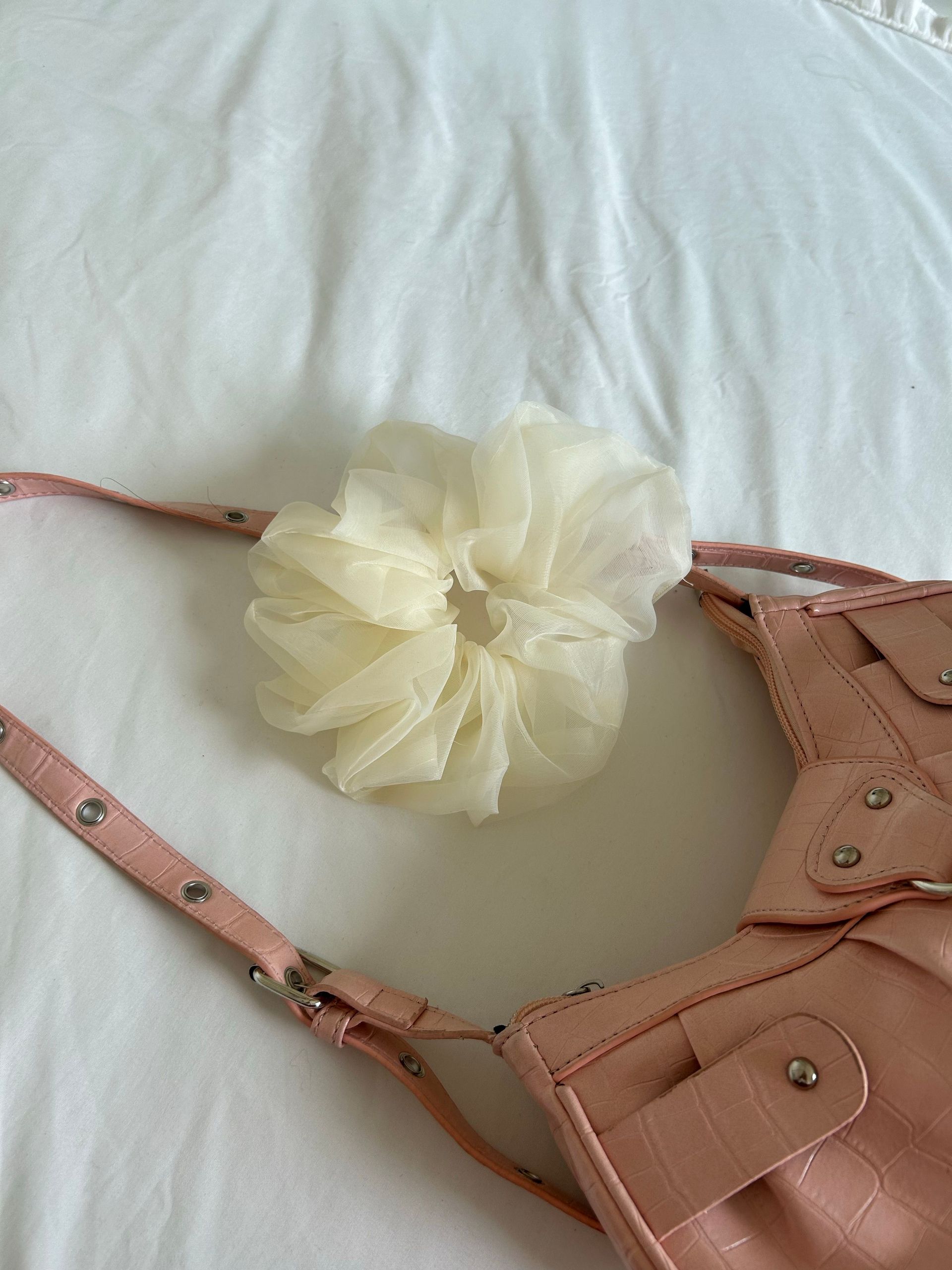 Small red and beige fabric drawstring pouch with white lining, standing upright on a white surface.