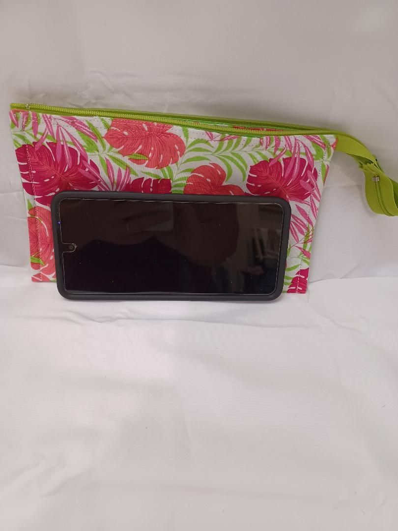Black smartphone resting on a pink floral zip pouch against a light background